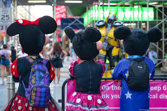 A photo of three Minnie Mouse costumed characters in Times Square